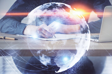 Double exposure of hands and notepad with business icons.