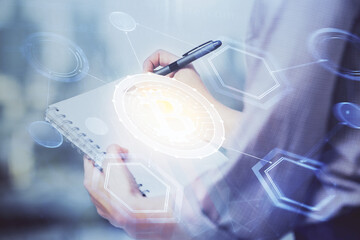 Cryptocurrency hologram over woman's hands writing background. Concept of blockchain. Double exposure