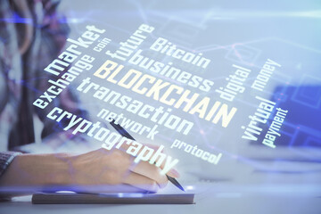 Cryptocurrency hologram over woman's hands writing background. Concept of blockchain. Multi exposure