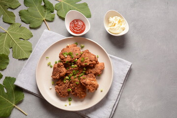 Fish in batter. Homemade Battered Fish Fry on the plate with fresh green onions. 
