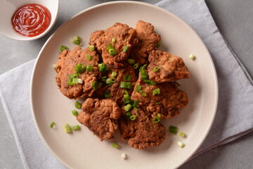 Fish in batter. Homemade Battered Fish Fry on the plate with fresh green onions. 