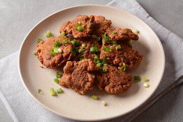 Fish in batter. Homemade Battered Fish Fry on the plate with fresh green onions. 