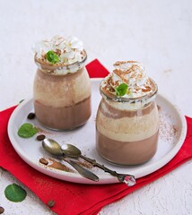 Dessert, two-layer chocolate and coffee panna cotta, decorated with whipped cream.