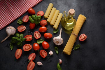 Beautiful tasty colorful pattern of italian pasta, tomatoes and Fresh Basil. Galic and olive oil. Food concept.Ingredients for cooking pasta on a vintage background