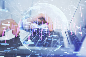 Double exposure of market chart with man working on computer on background. Concept of financial analysis.