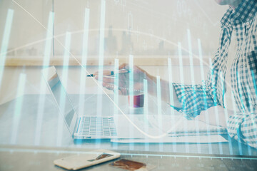 Obraz premium Multi exposure of stock market chart with man working on computer on background. Concept of financial analysis.