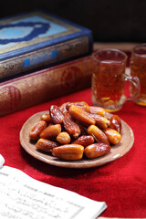 Fototapeta premium Dates fruit and Islamic Book Koran on carpet background