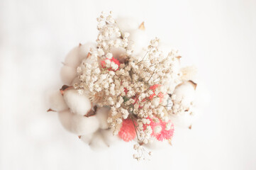 art photo of a bouquet of white flowers and cotton with pink elements on a white background