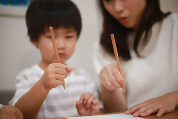 えんぴつの持ち方の練習をする親子