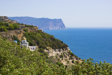 scenic view of the Black Sea, Crimean mountains and St. Gergiev Monastery surrounded by bright greenery