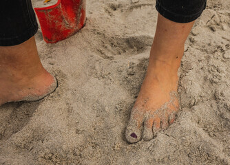 Sandy Feet surrounded by shells on a summers day at the beach
