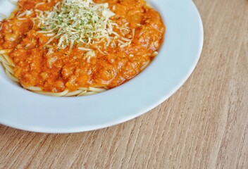 Close up of spaghetti bolognaise on a white plate.