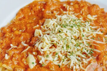 Close up of spaghetti bolognaise on a white plate.