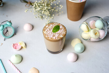 Clear glass with tasty cold whipped coffee with meringues on a white background. Pastel gentle colors. Concept of a calm serene and happy summer morning