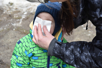 grandma blowing her grandson's nose