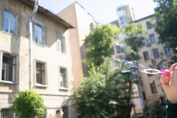 Multi-colored soap bubbles fly in the air girl will think up a lot of soap bubbles