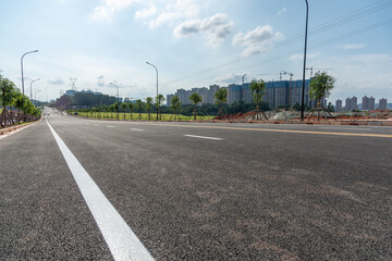 Fototapeta na wymiar Low angle view of urban suburban asphalt road and buildings