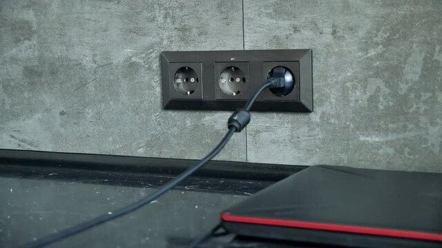 Many gadgets and Mobile Phone Charging power bunk on the Table. Recharge phones. A lot of wires to chargers in sockets. Smartphones connected to charging on a table.