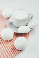 Fototapeta na wymiar Cup of cappuccino and white marshmallows on white background