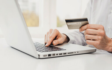 Man hand holding credit card and using laptop at home, Businessman or entrepreneur working, Online...