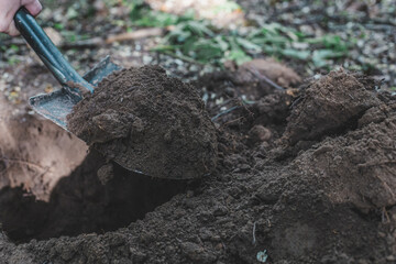 picked up a shovel with the ground, digging a hole