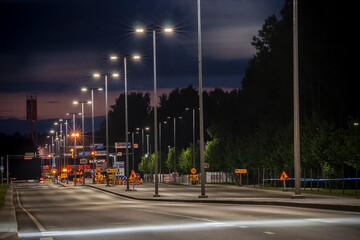 A beautiful view of an empty city street at night with street lights and construction signs, shot...