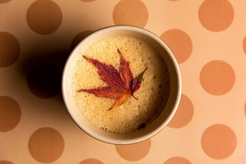Coffee with autumn leaf on a table