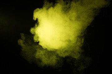 Colorful smoke close-up on a black background. Yellow cloud of smoke.