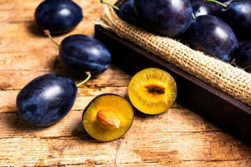 Plums on rustic wooden table