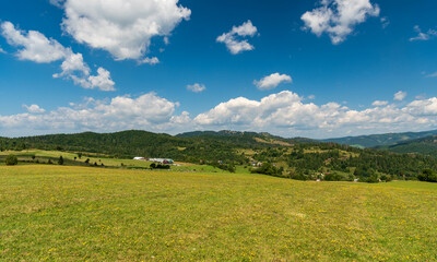 Fototapeta na wymiar Beuatiful surrounding of Lutise village in Slovakia with meadows, houses and farm of uuper part of Lutise village, sheep, chapel on Zlien hill and hills