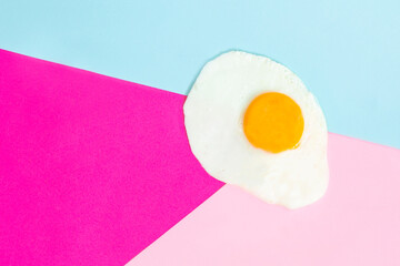 One fried egg on pink background, pop art, isolated from the right side