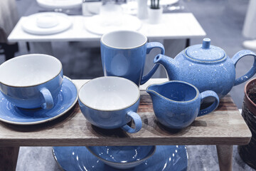 Blue porcelain tableware for tea on a wooden stand.