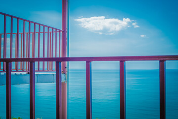 Fototapeta na wymiar Metal grille fencing against the blue sky. Observation terrace on a background of blue sea. Playground in a mountain hotel. Spring. Georgia.