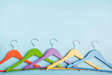 Fototapeta na wymiar Multi-colored clothes hangers on a blue background. Concept of shopping and sale.