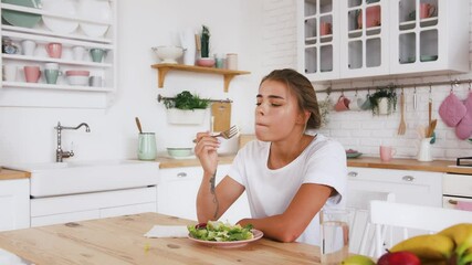 Tattooed model sitting at table, feeling sad and unhappy with diet not wanting to eat salad. Healthy nutrition or food, eating disorder. Close up