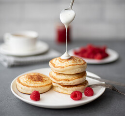 pancakes with raspberry jam, sour cream and powdered sugar