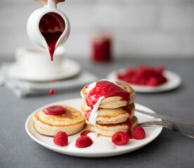 pancakes with raspberry jam, sour cream and powdered sugar