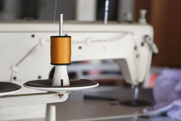 Brown thread roll of sewing machine for sew cloth or fabric close-up.