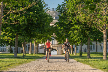 Grandmother and granddaughter riding their mountain bikes and having fun on a sunny afternoon in in...