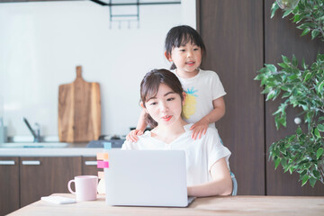 子供と遊びながらテレワークをする女性