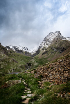 Monta&ntilde;a nevada con camino de piedras en primer plano. Ib&oacute;n de Llauset pico Culebras, pirineo aragon&eacute;s