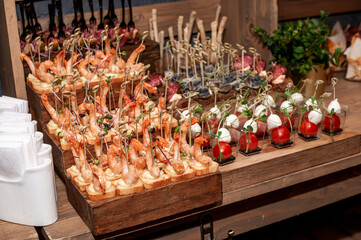 Wedding buffet. Prawns with croutons on a wooden stand