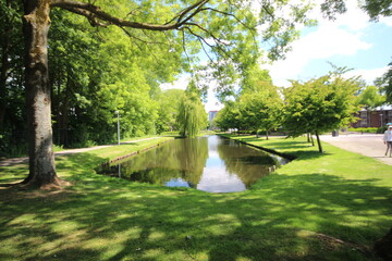 Sky and trees are reflecting on the water surface in NIeuwerkerk aan den IJssel in the Netherlands.
