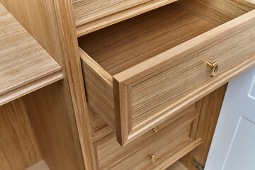Naklejka na ściany i meble Wooden drawers of wardrobe close-up. Wooden wardrobe with wooden drawers and shelves. Wooden filling of wardrobe