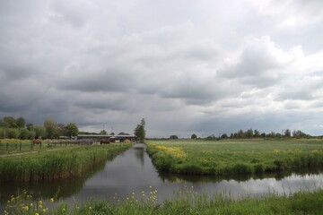 Fototapeta na wymiar Dark cumulus clouds above the meadows and agriculture fields in the Zuidplaspolder in the Netherlands.