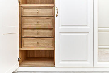 Fototapeta premium White wardrobe with wooden drawers and shelves. Wooden filling of wardrobe