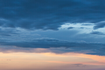 Gray sky with dark clouds before thunderstorm. Summer sunset.