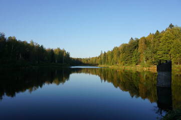 Forest lake at the end of September. Peaceful contemplation. Autumn in the Moscow region, Russia.