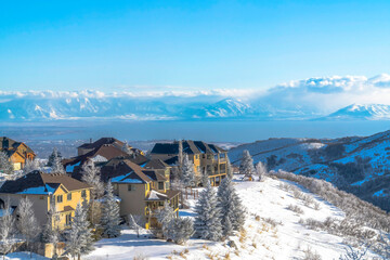 Homes on pristine snowy terrain overlooking valley lake and Wasatch Mountains
