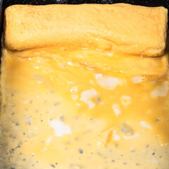 Cooking tamago Japanese omelet in a special pan for tamagoyaki, close-up